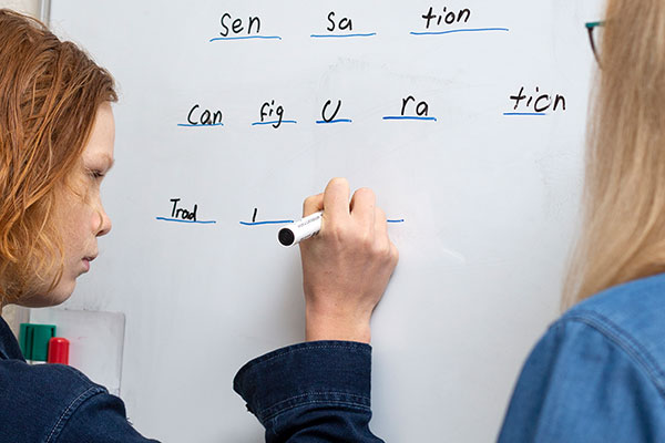 boy using msl method to practice writing on a whiteboard